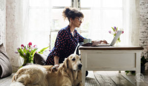 Young woman and dog owner researching online pet grooming academy