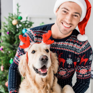 dog owner and his dog wearing christmas outfits as holiday gifts