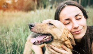 Dog training quiz, July 30 2021, in-post image, happy adult women cuddling dog in a field